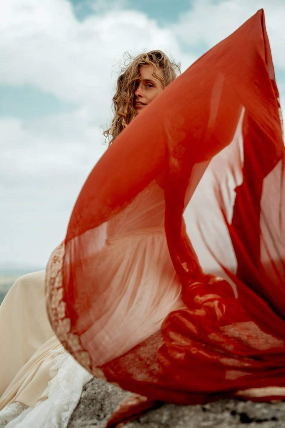 Red fabric flowing against the sky