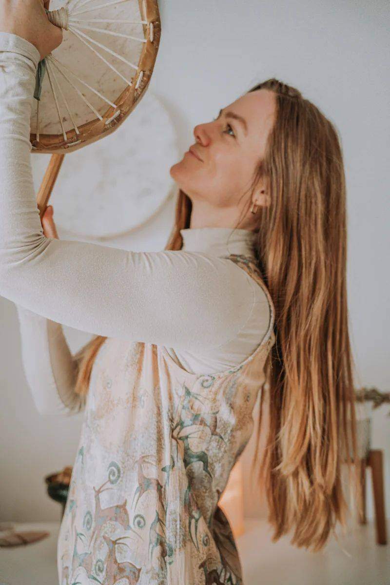 Cassandra holding a frame drum above her head