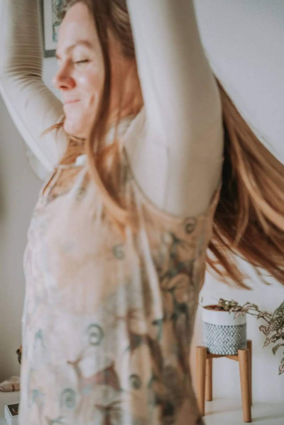 Cassandra with her hair moving, arms raised