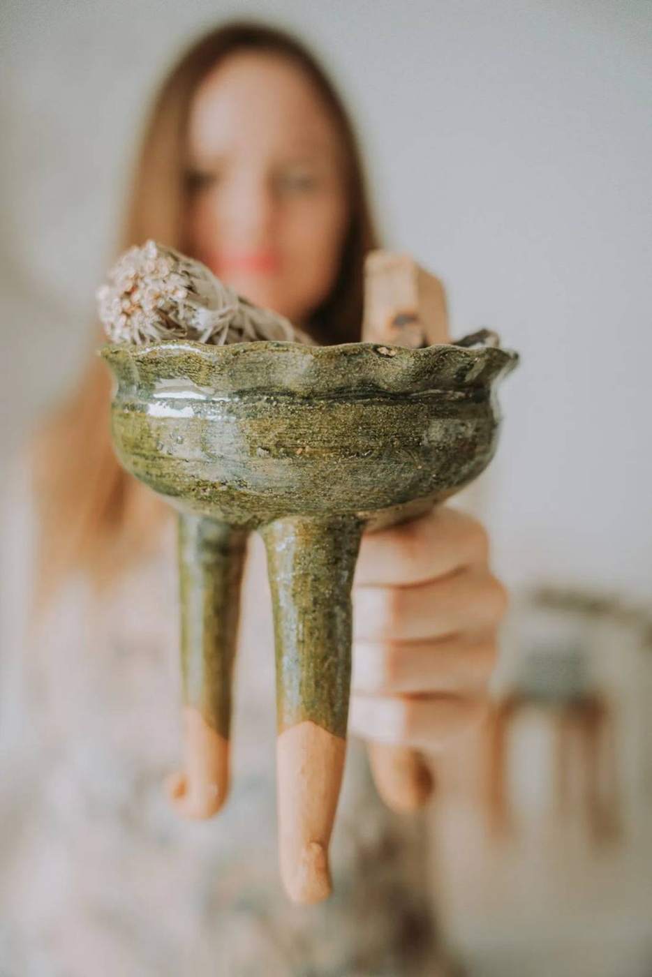 Cassandra holding out a ceramic vessel
