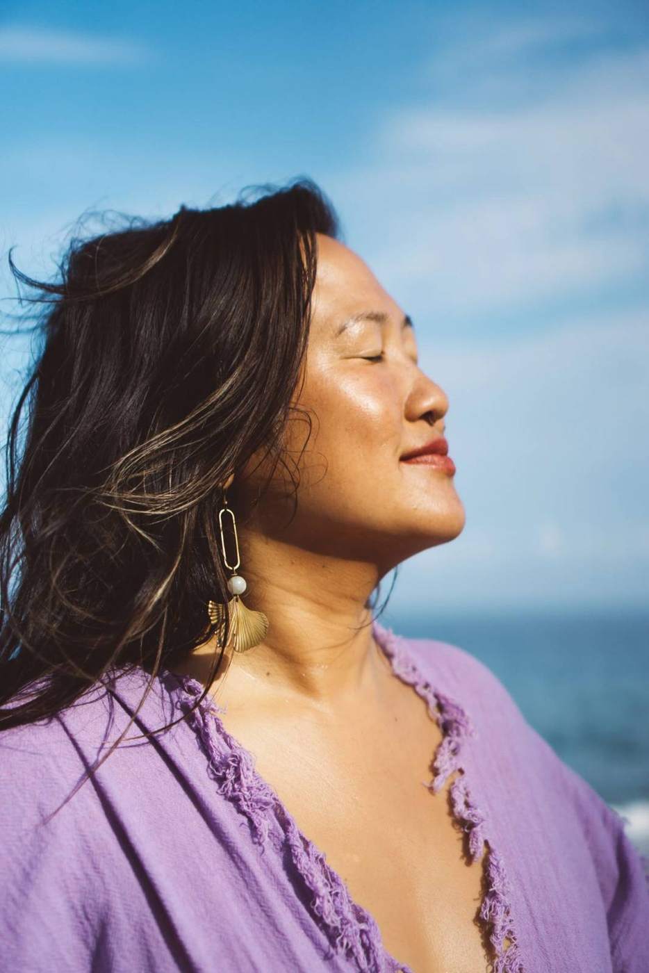Lotus Wong in sunlight against the sea